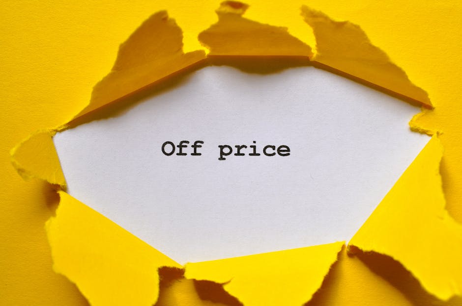 A torn yellow paper background reveals a white inner sheet with the words 'Off price' printed in black text, symbolising discounted or reduced costs. The torn edges of the paper are irregular and jagged, emphasizing a reveal or discount offer. The setting is neutral, with no additional objects, and the focus is on the contrast between the bright yellow exterior and the plain white interior, reflecting a promotional or marketing theme related to house removals or relocation services. This visual could be used to illustrate cost savings or special offers within the context of home moving or furniture transport services offered by Man with Van Oakleigh Park, especially connected to the topic of hidden fees or pricing transparency in house removals.